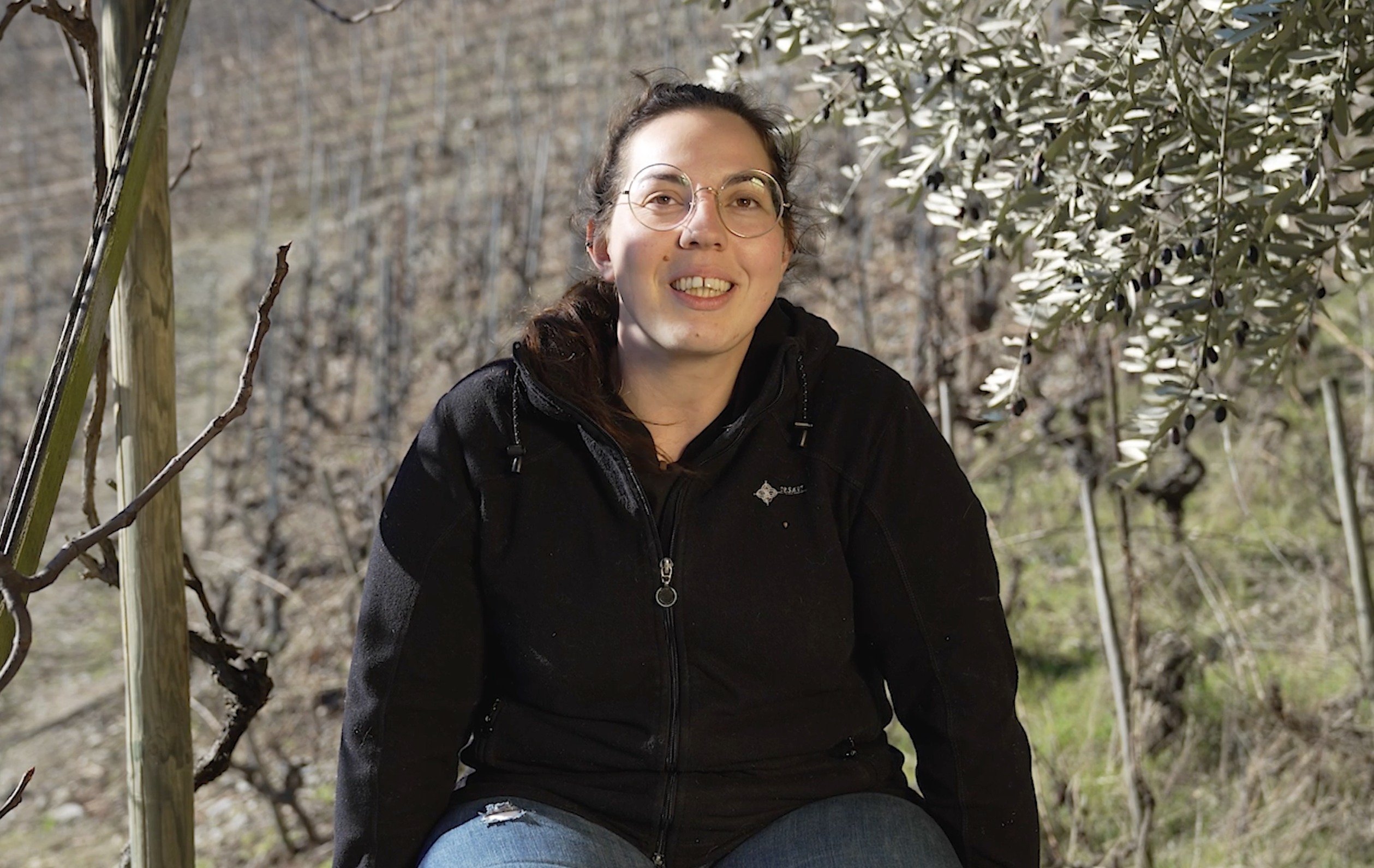 Portrait de Laetitia Roduit, jeune vigneronne assise dans les vignes